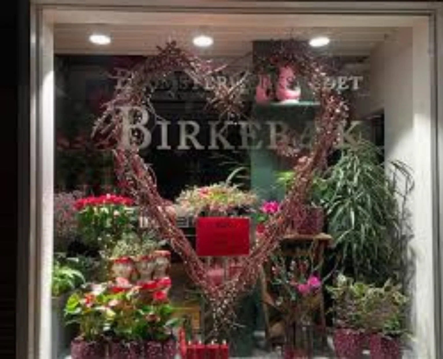 Hjertedekoration af blomster i butiksvinduet