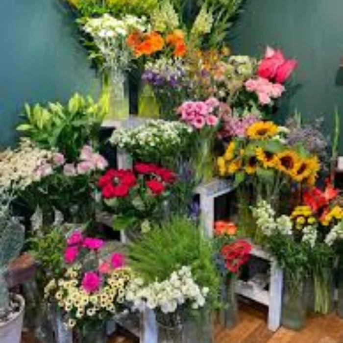 Spande med friske afskårne blomster foran butikken
